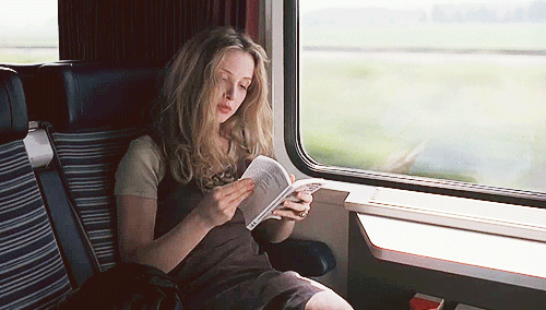 GIF chica en un tren leyendo un libro mientras viaja 