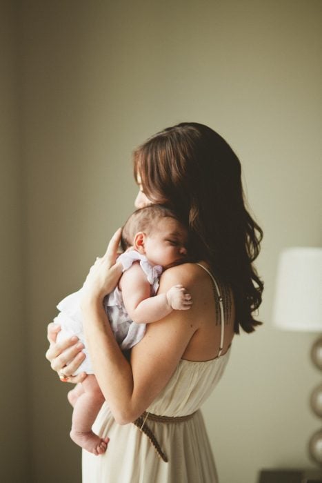 mujer cargando a un bebé sobre su pecho 
