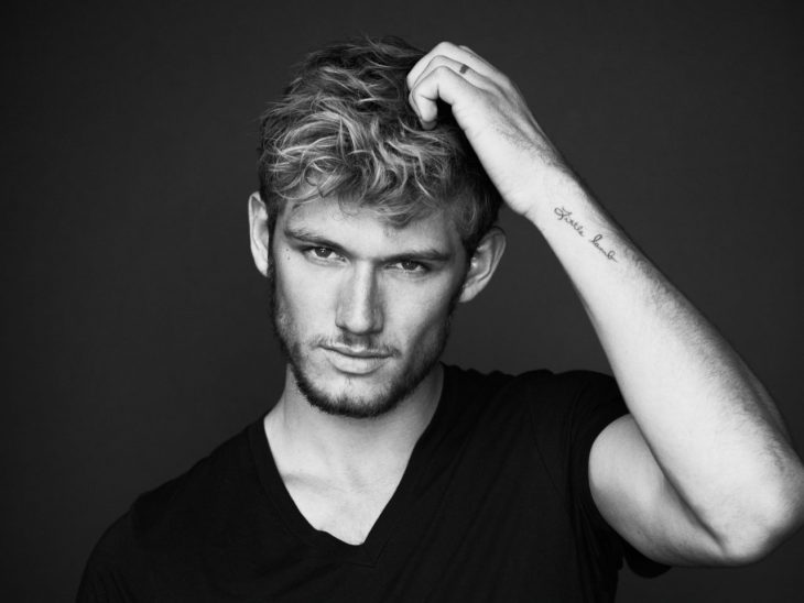 Alex Pettyfer blanco y negro tocándose la cabeza