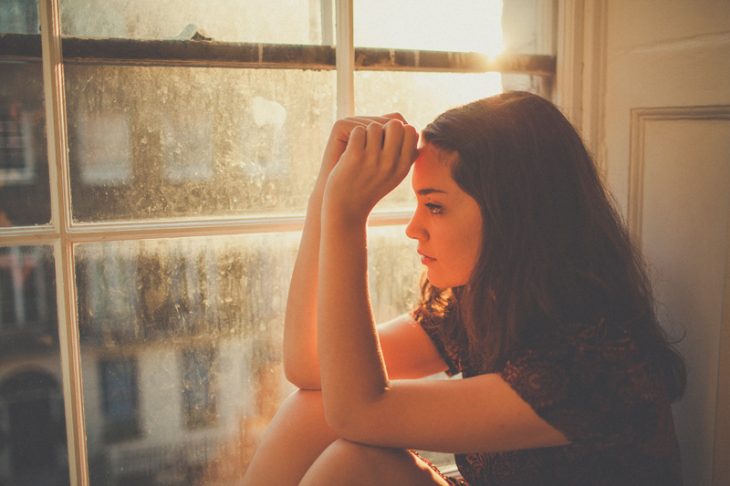 Chica sentada mirando por la ventana 