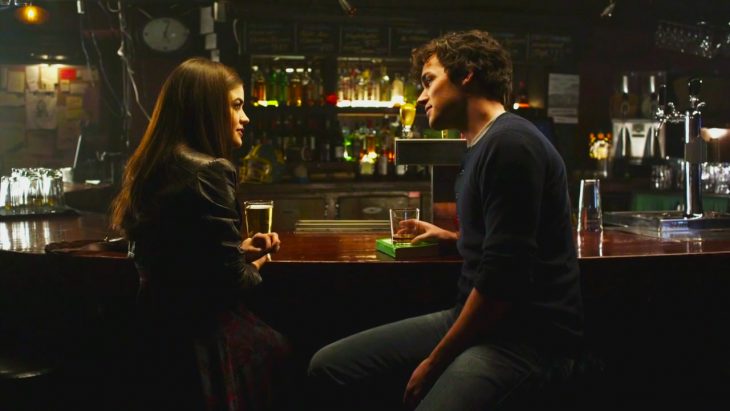 Escena de la serie pretty little liars pareja de novios hablando en la barra de un bar 