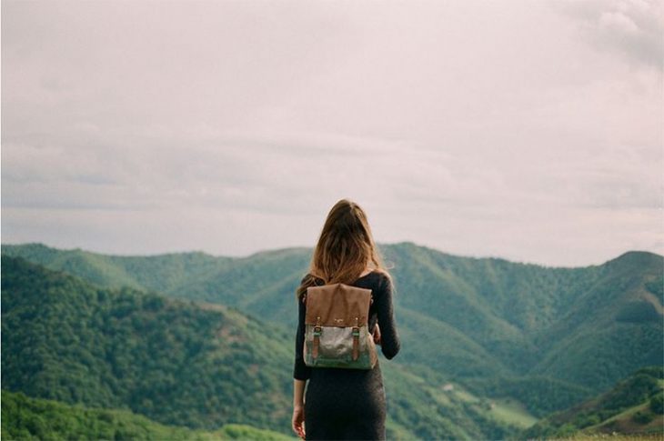 foto chica de espaldas con mochila en un monte