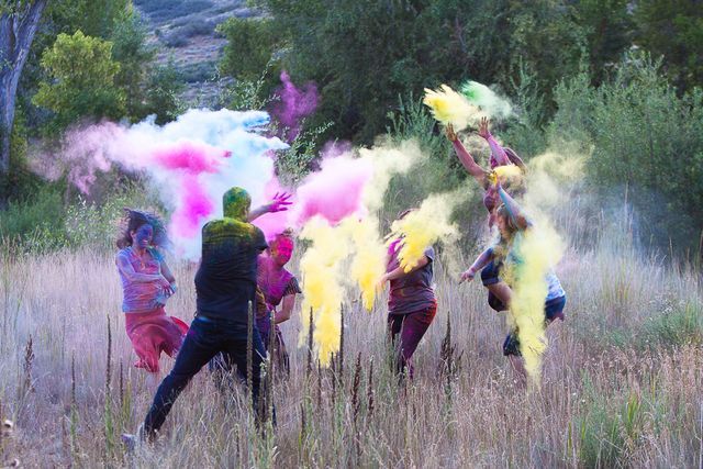 amigos aventandose polvo de colores en el campo