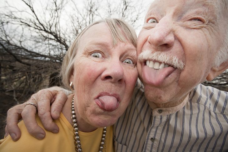 Pareja de adultos mayores sacando la lengua