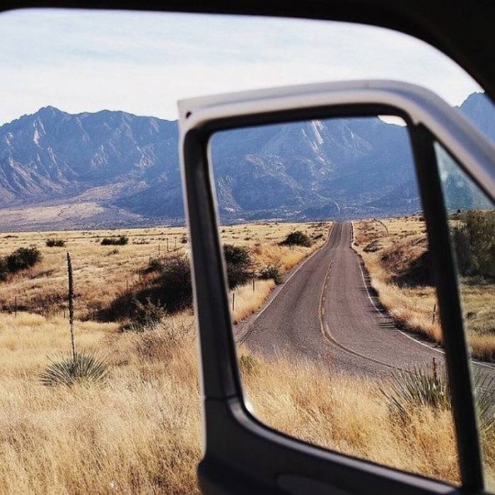 fotografía de carretera a través de la puerta de una camioneta