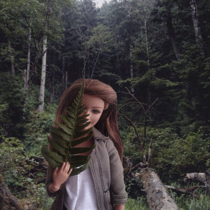 Fotografías de Barbie hipster en el bosque con una hoja en la mano