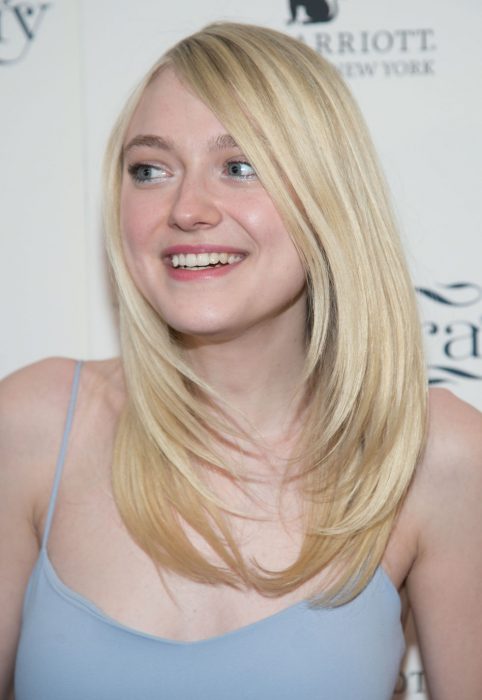 Dakota fanning posando en una alfombra roja 