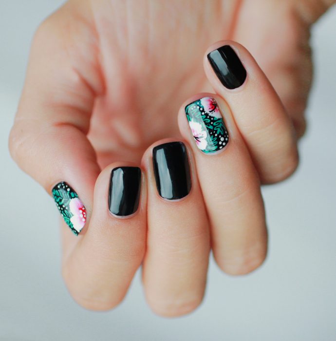 Uñas de color negro con diseños de flores en color verde 