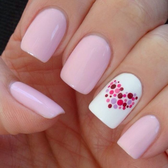 Uñas rosas con un corazón de puntos 