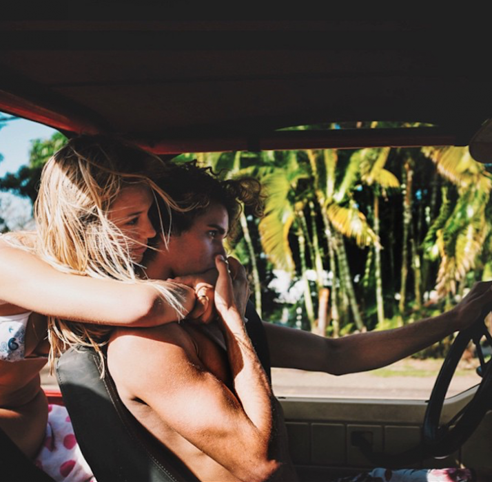 Chica abrazando a su novio por la espalda en una camioneta 