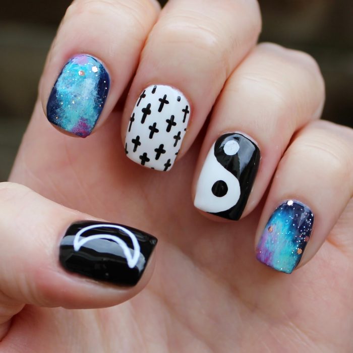 Uñas a blanco y negro con cruces, yin yang, media luna y la galaxia 