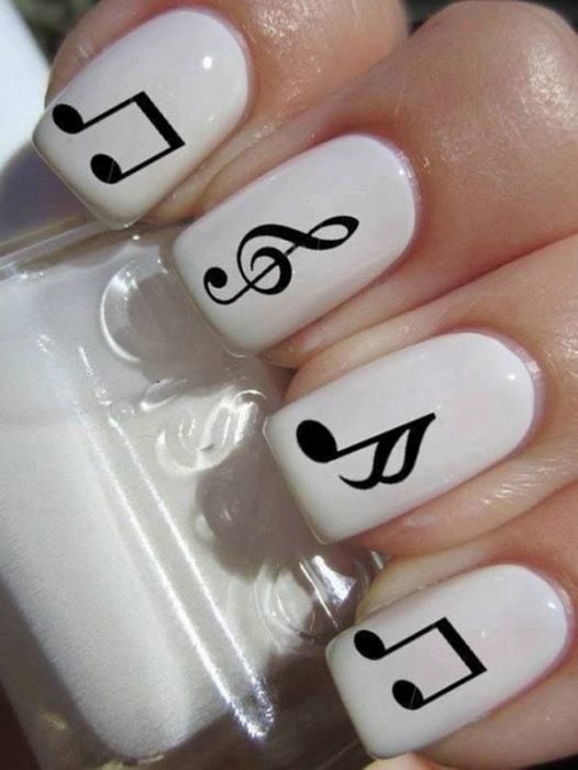 Uñas a blanco y negro con letras musicales 