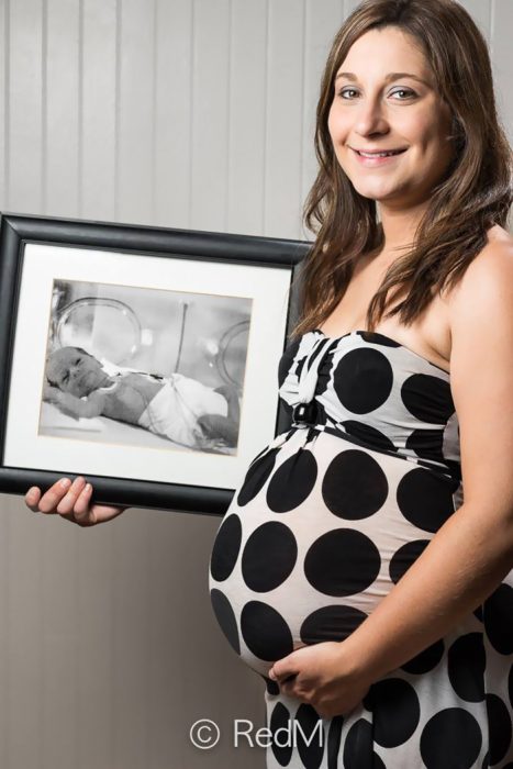 mujer sosteniendo una fotografía de ella misma cuando era una bebé