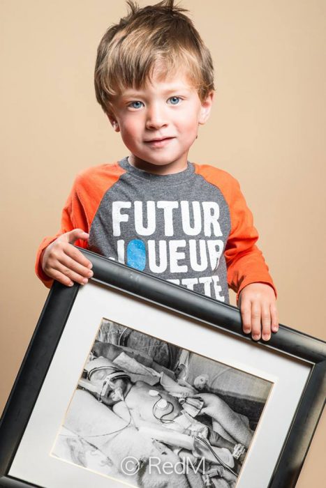 Niño sosteniendo una fotografía de él mismo cuando era bebé