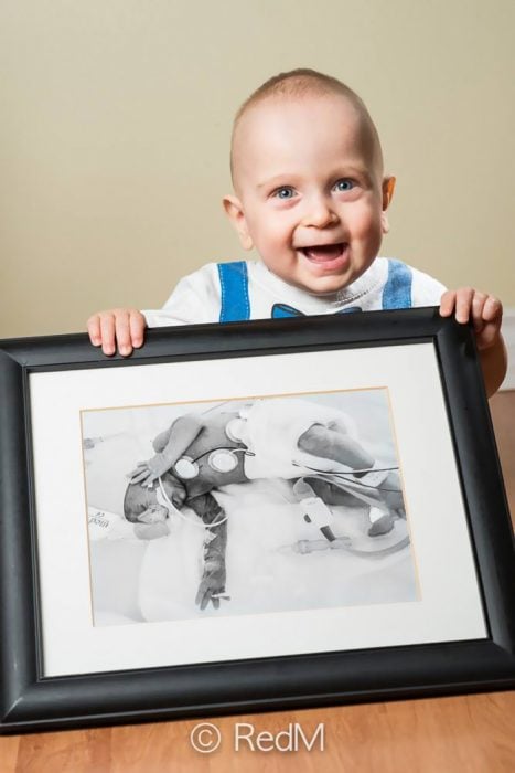 Niño sosteniendo una fotografía de él mismo cuando era un bebé prematuro 
