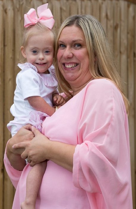 Bebé síndrome Down Connie Rose en brazos de su mamá Julie