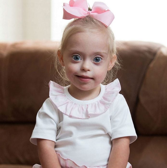 Bebé síndrome de down sentda en sillón Connie ROse