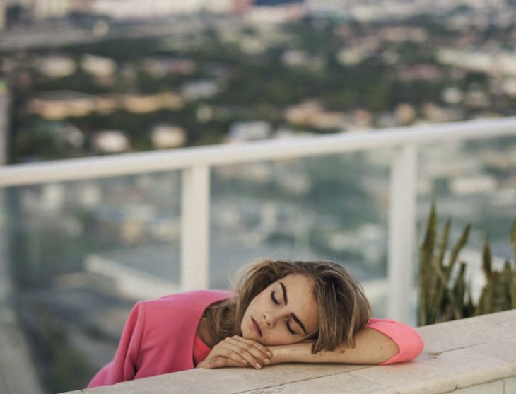 Cara Delavinge dormida sobre una tabla de madera