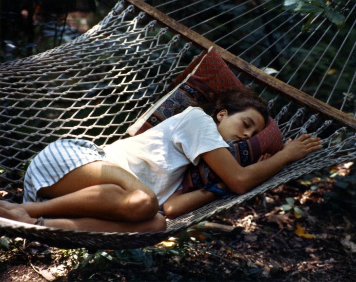 chica durmiendo en una hamaca en el jardín 