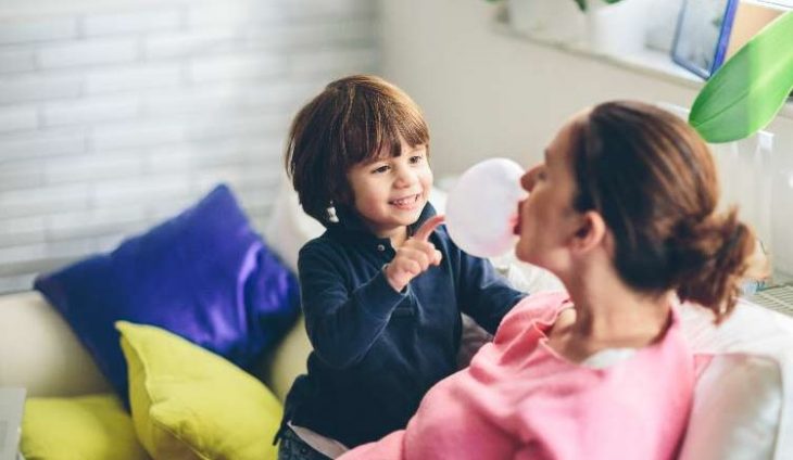 niño con mujer haciendo una bomba de chicle