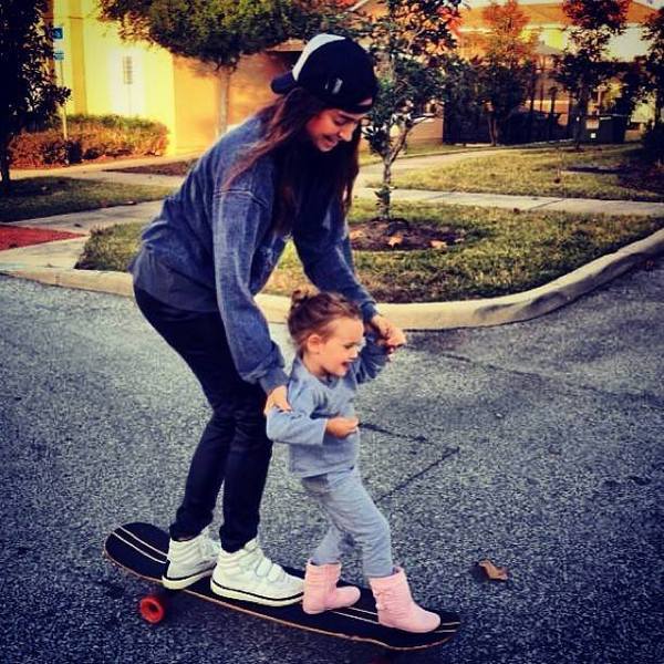 chica y niña pequeña en patineta