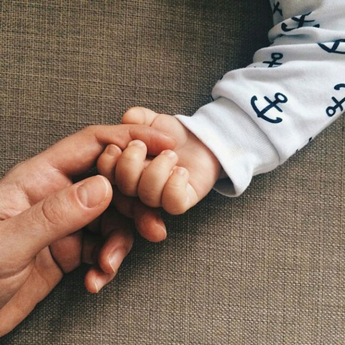 mano de mujer y bebé tocándose