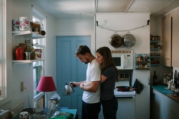 mujer abraza a hombre que está cocinando