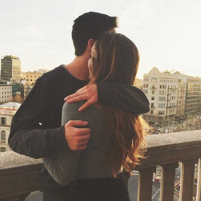 pareja abrazada en un balcón