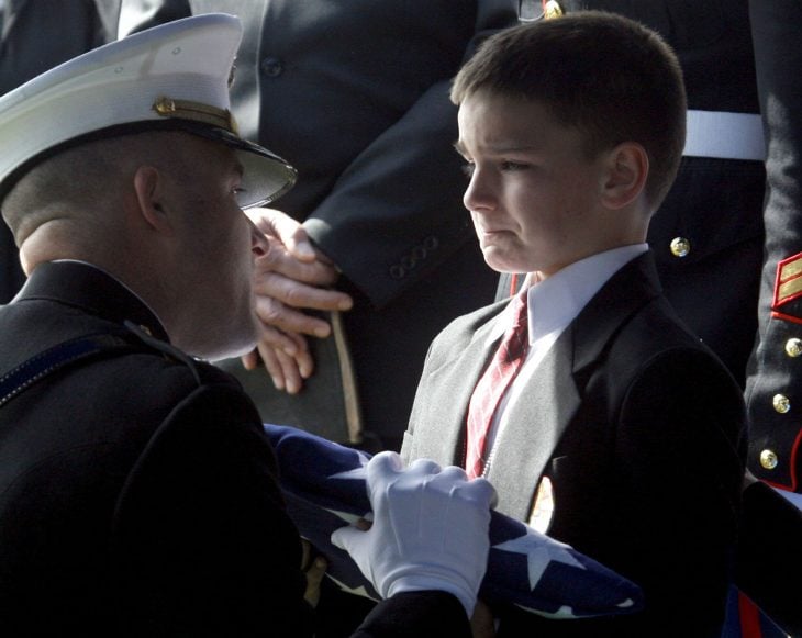 niño recibe la bandera de su padre muerto en Irak