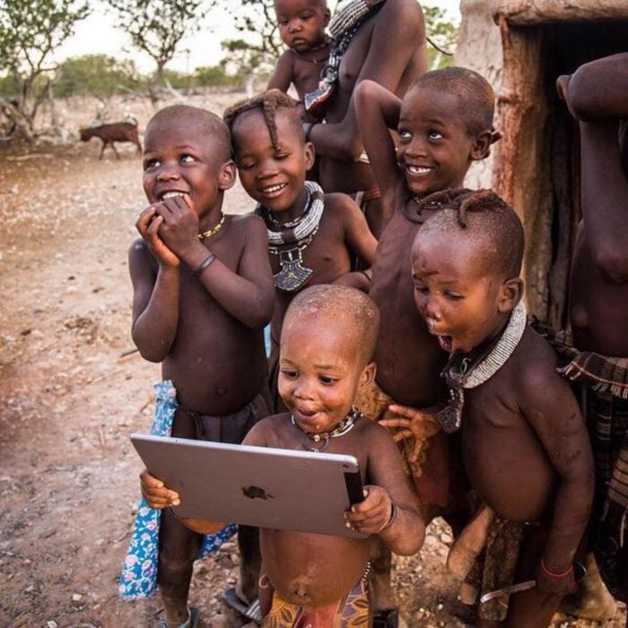 niños africanos sonríen al ver una tableta