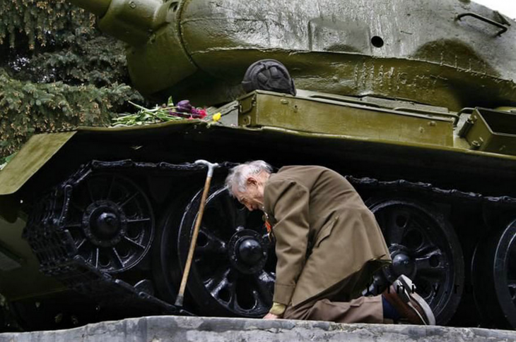 soldado ruso se arrodilla frente a tanque de guerra