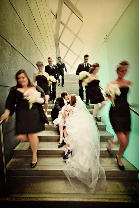 novios al centro y damas en movimiento bajando escalers