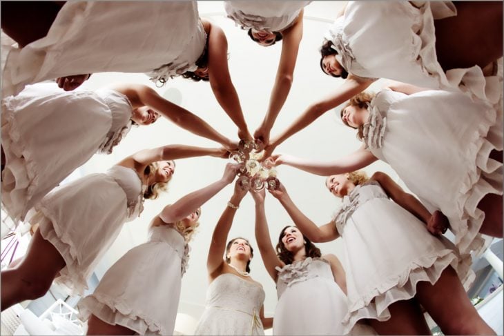 fotografía tomada en contrapicada de damas brindando en círculo