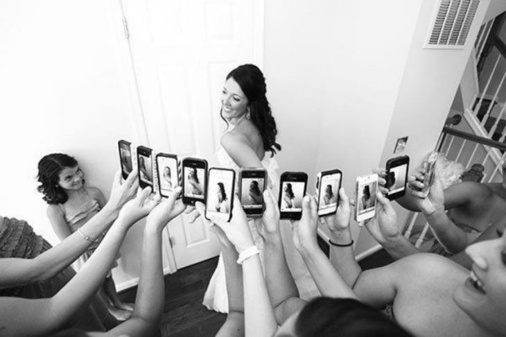 damas tomando fotografía a novia con sus celulares