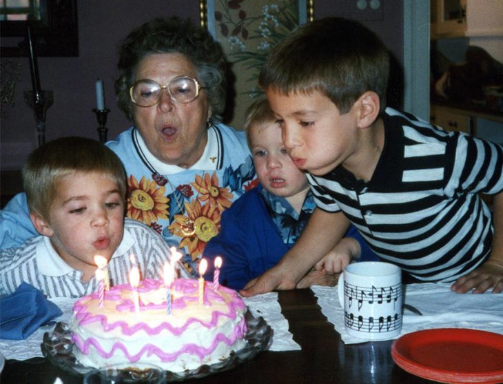 Niños soplando una vela de un pastel de cumpleaños 