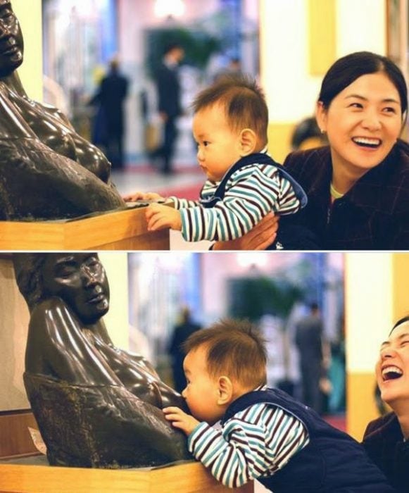 Niño tomando el pecho de una estatua 