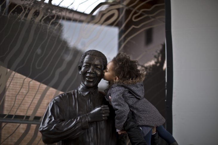 Niño besando a una estatua en forma de señor 