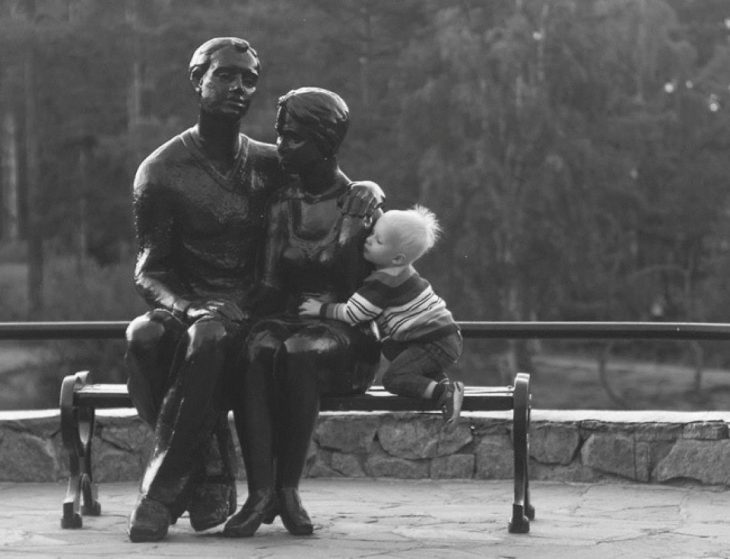 Niño abrazando a unas estatuas