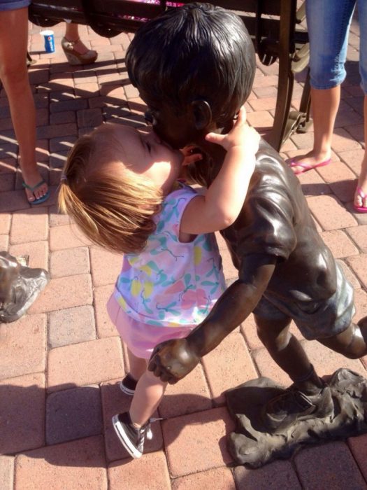 niña besando a una estatua