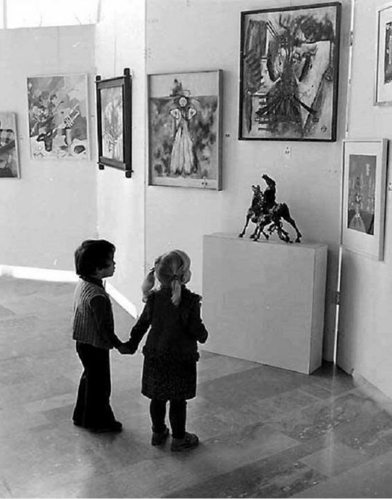 Niños observando muy atentamente a unas estatuas en un museo 