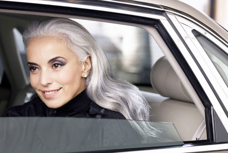 Modelo de 59 años de edad sobre un carro sonriendo durante una sesión de fotos 