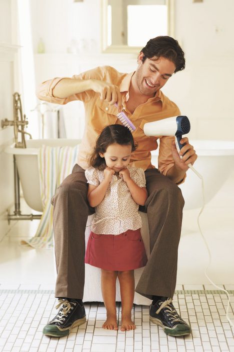 padre peinando a hija