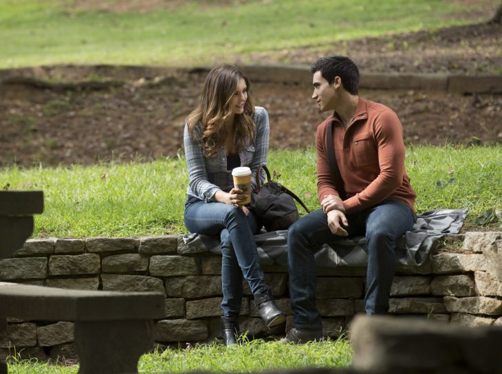 pareja de novios sentados en el parque conversando mientras toman café