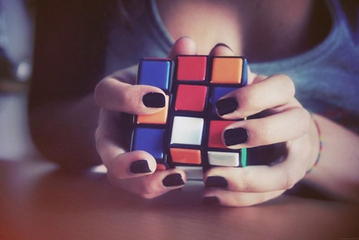 Chica jugando con un cubo de rubik 