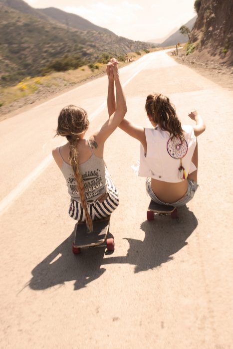 amigas en una patineta en una carretera 