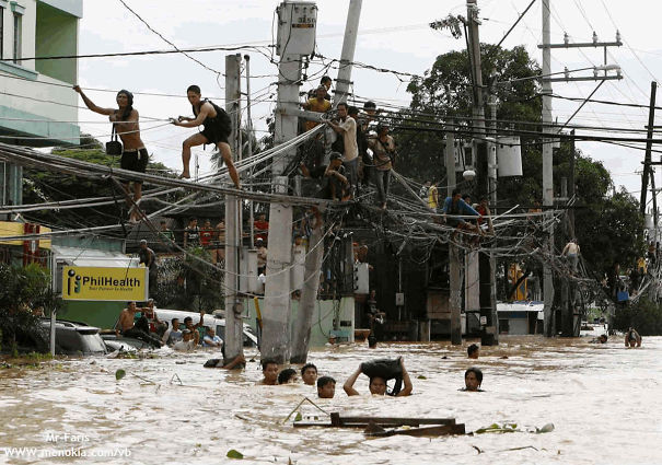 Hombres cruzando un rio sobre cables de luz