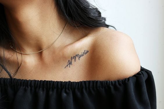 Chica usando un tatuaje en el hombro con la palabra Ad maiora