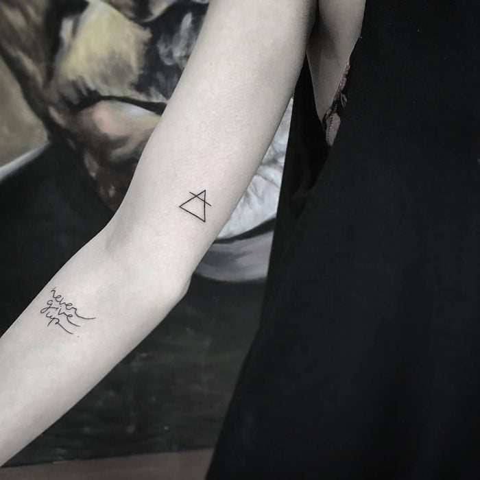 Chica con un tatuaje de triangulo en el brazo 