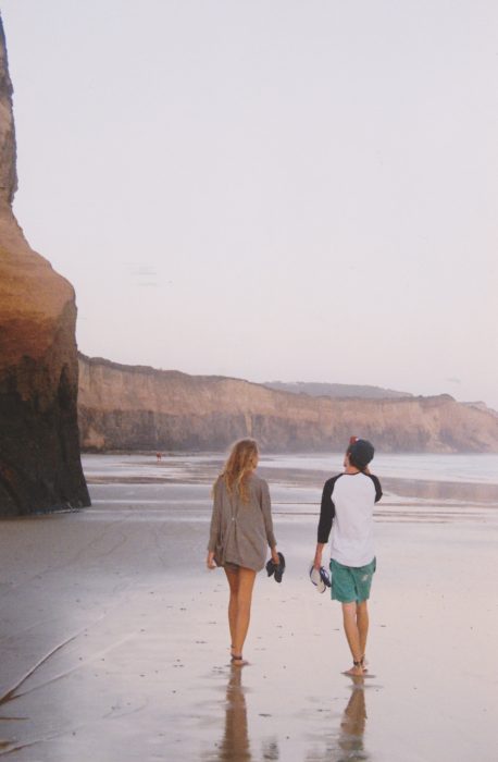 Pareja de novios caminando por la playa 