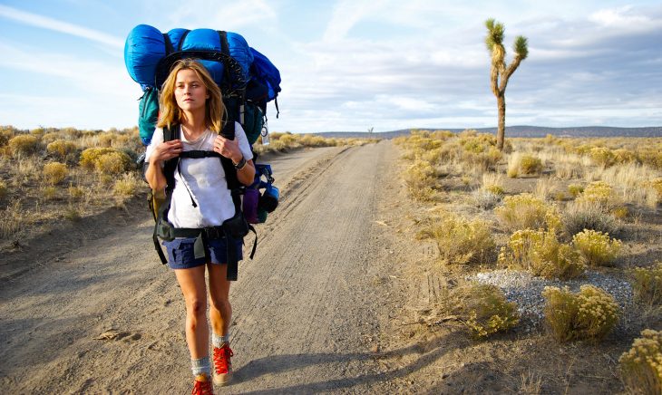 chica caminando por carretera con backpack